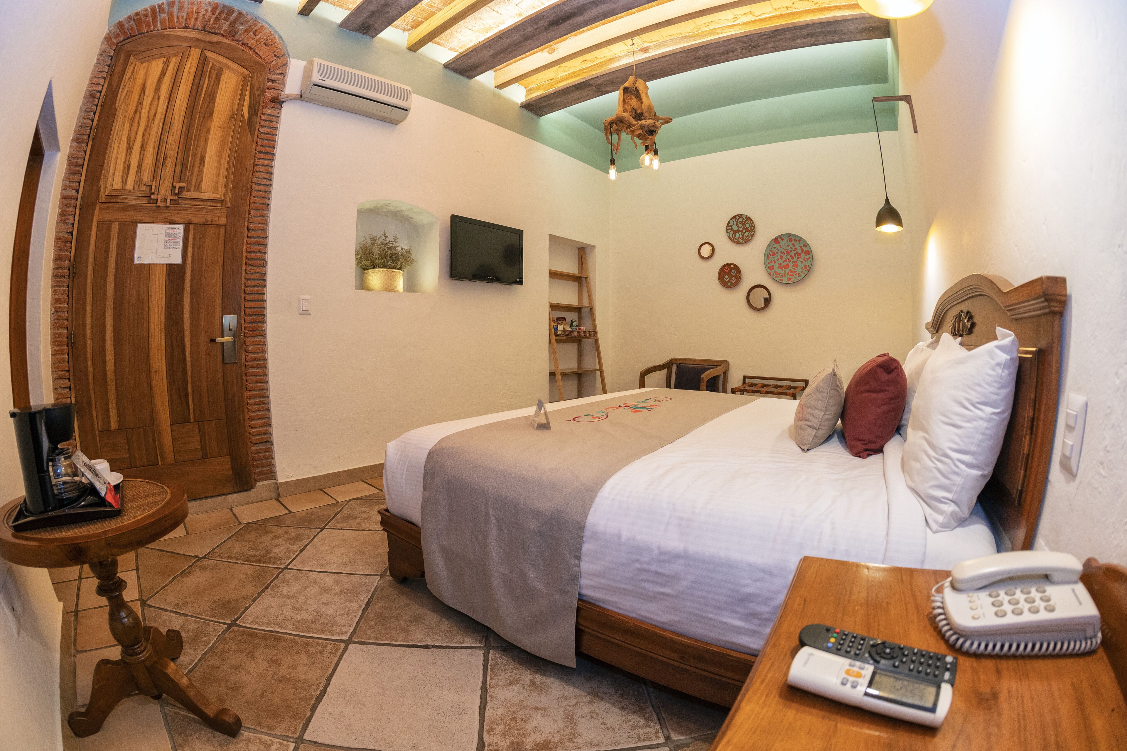A bedroom with a bed, bedside table, and a telephone.