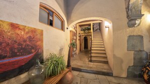 A hallway with a staircase, a painting, and potted plants. - Casa De Sierra Azul (Oaxaca)