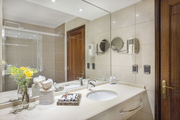 Un baño moderno con un espejo grande, un lavamanos y una ducha.