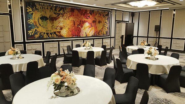 A conference room with multiple round tables, each with a white tablecloth and black chairs. There are floral centerpieces on the tables. - Hotel Marinela Sofia (Sofia)