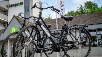 A bicycle parked in front of a building with a sign that reads "Campanile Hotel Restaurant".