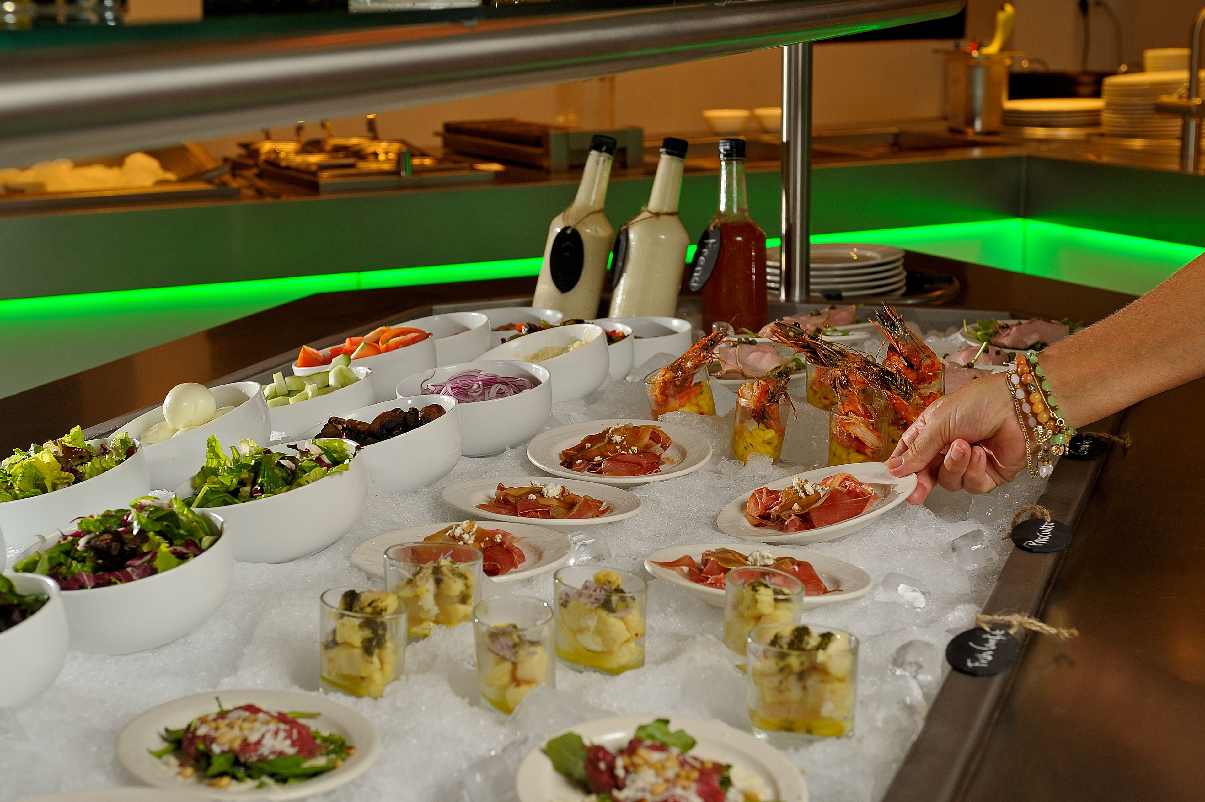 A buffet with various dishes and drinks on ice.