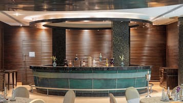 A modern bar area with a circular design, wooden paneling, and a central bar counter.