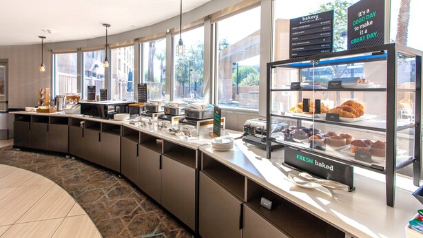 A breakfast bar with a variety of baked goods and a sign indicating fresh baked items. - Holiday Inn & Suites Scottsdale North - Airpark by IHG (Scottsdale)