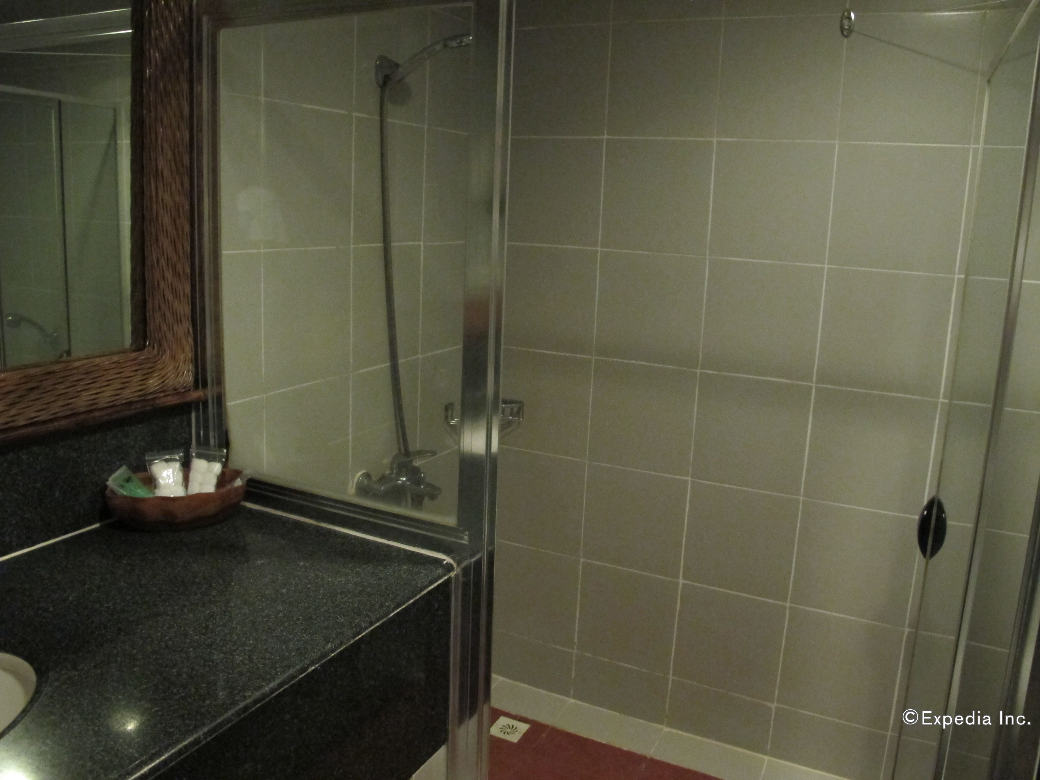 Un baño con cabina de ducha de vidrio, un lavabo con espejo y un perchero para toallas.