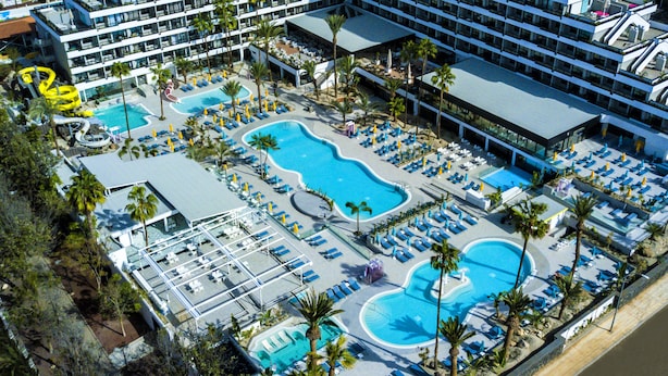 A hotel with multiple swimming pools, sun loungers, and palm trees. - Spring Hotel Bitácora (Arona)