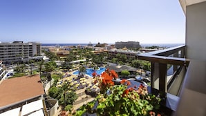 A resort with a pool area, palm trees, and a view of the ocean. - Spring Hotel Bitácora (Arona)