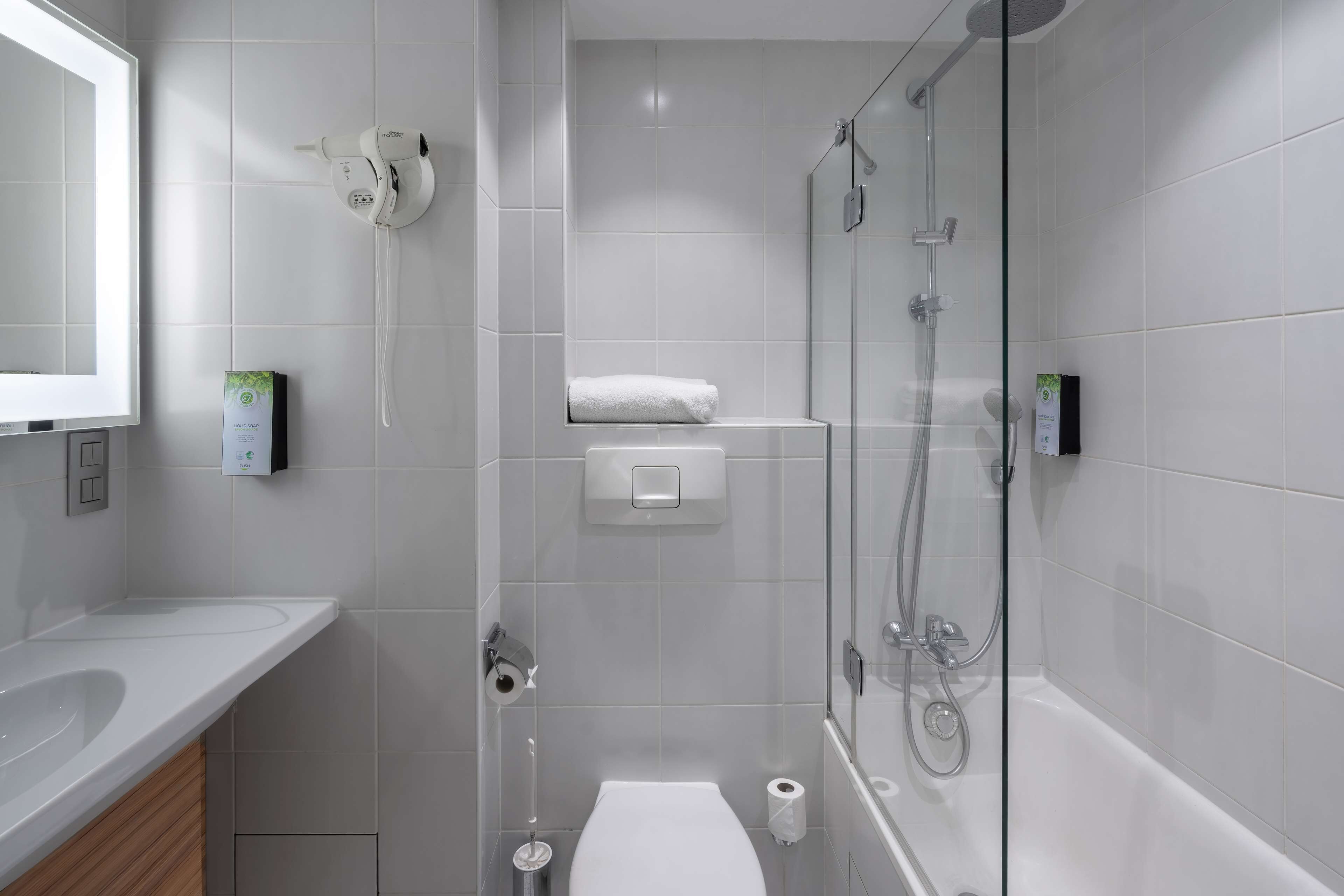 Un baño moderno con cabina de ducha de vidrio, inodoro y lavamanos.