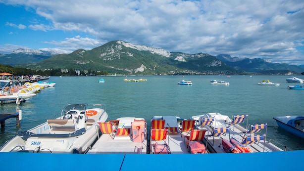 Eine Marina mit vertäuten Booten, ein Berg im Hintergrund und ein klarer Himmel.