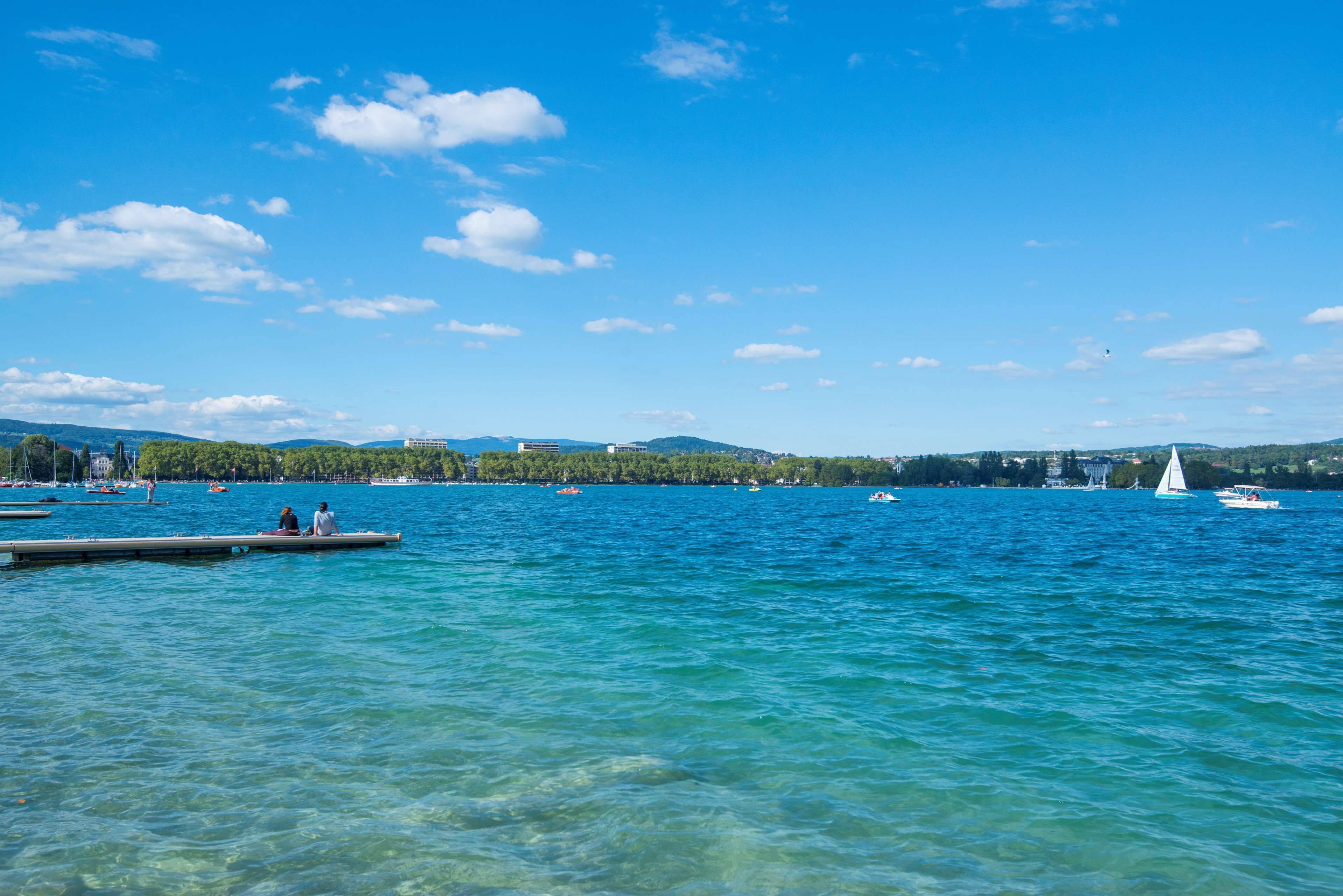 A calm lake with boats and a dock.