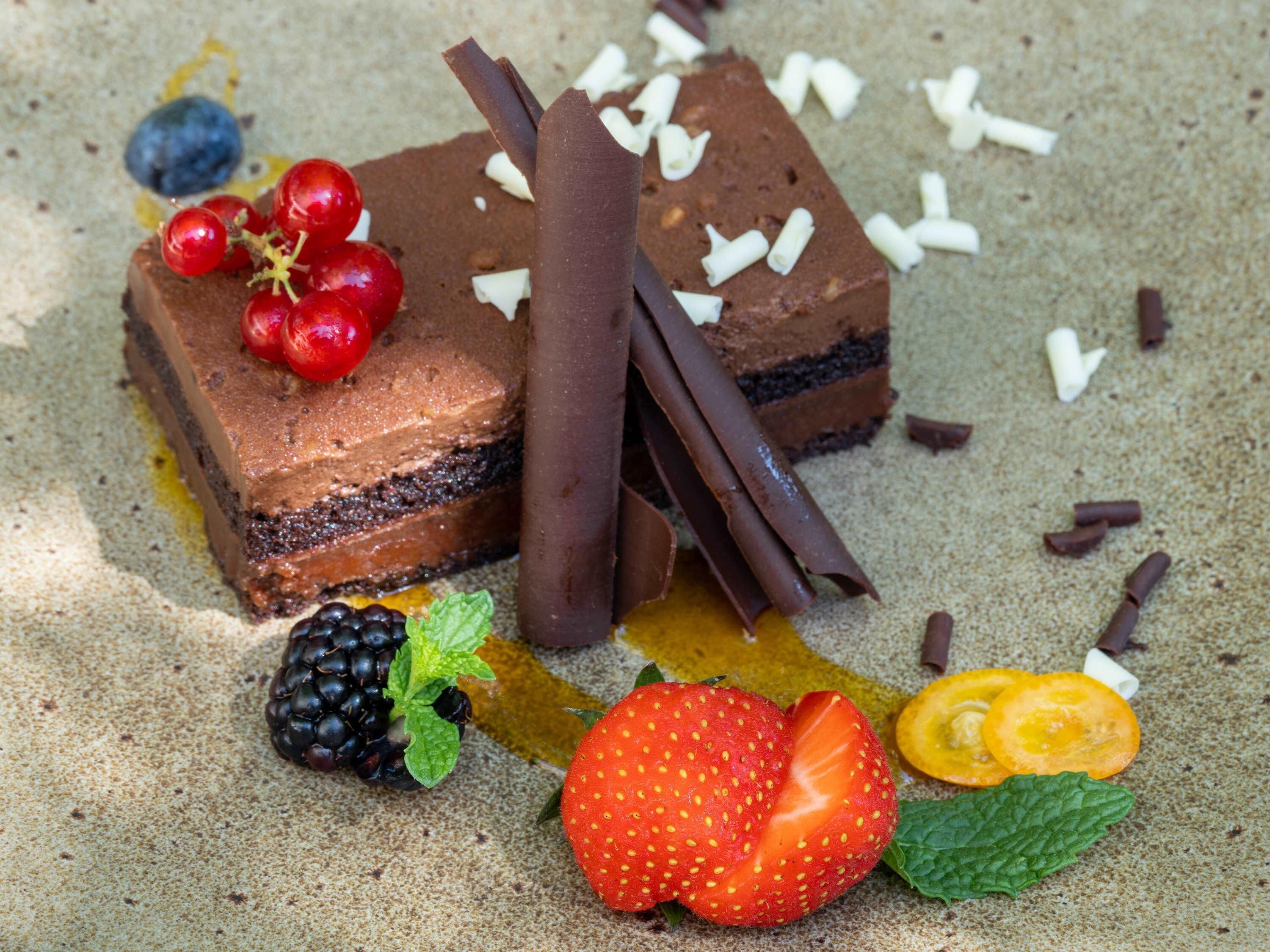 A dessert with chocolate, berries, and chocolate shavings.