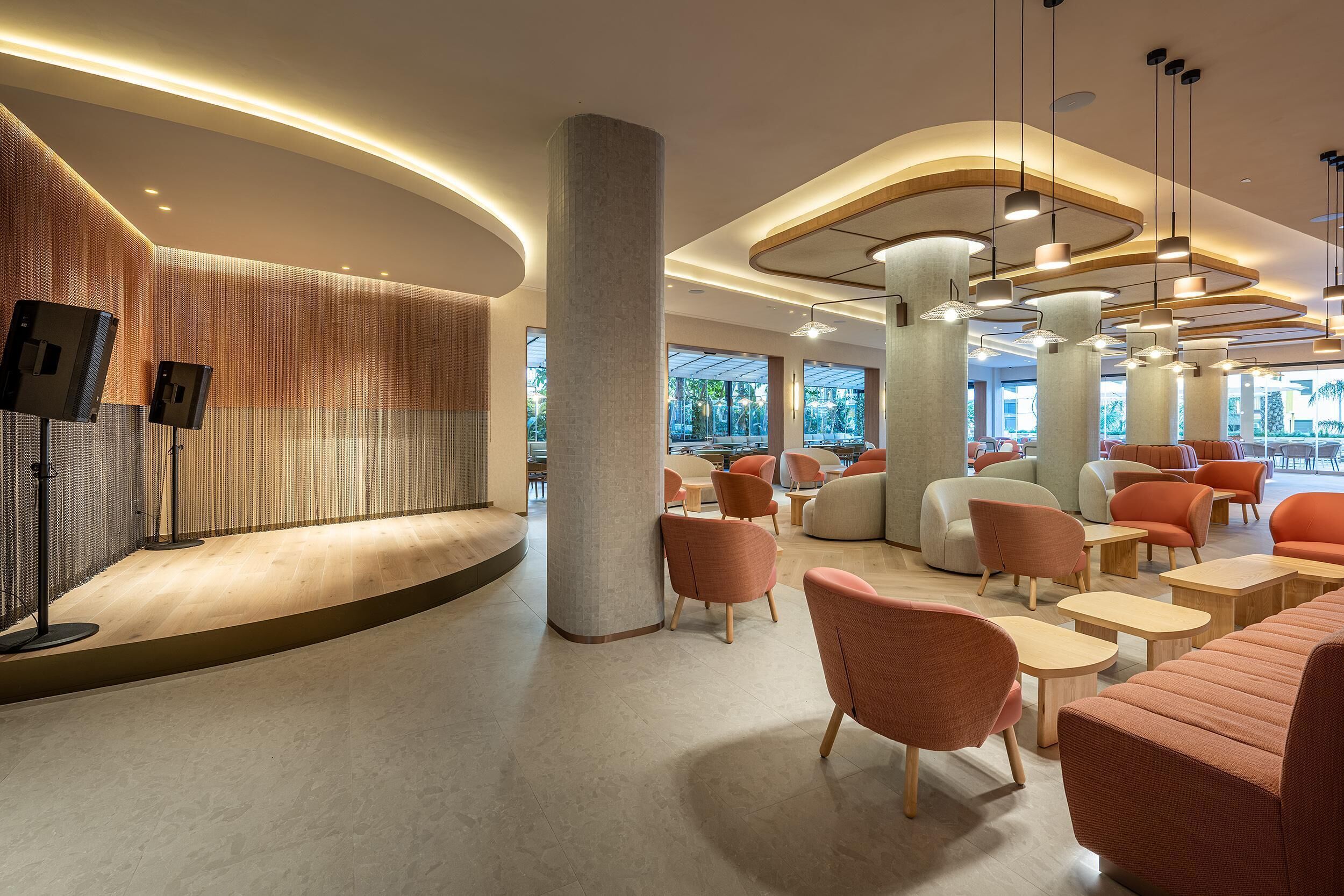 Un intérieur moderne avec un mur incurvé, des espaces de détente et de grandes fenêtres.