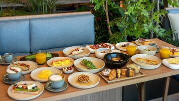 A breakfast buffet with various dishes and beverages.