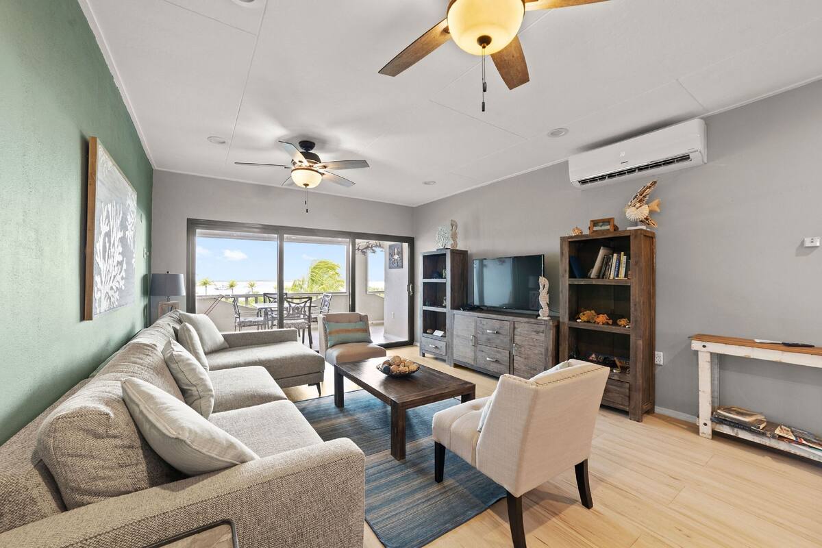 A living room with a sofa, armchair, coffee table, and entertainment unit.