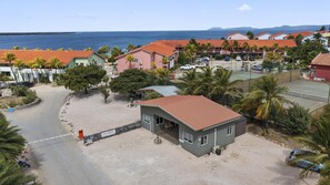 A coastal resort with a sandy beach, a tennis court, and a view of the ocean. - Sand Dollar Bonaire (Kralendijk)