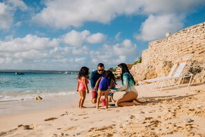 Praia particular, areia branca, espreguiçadeiras, toalhas de praia 
