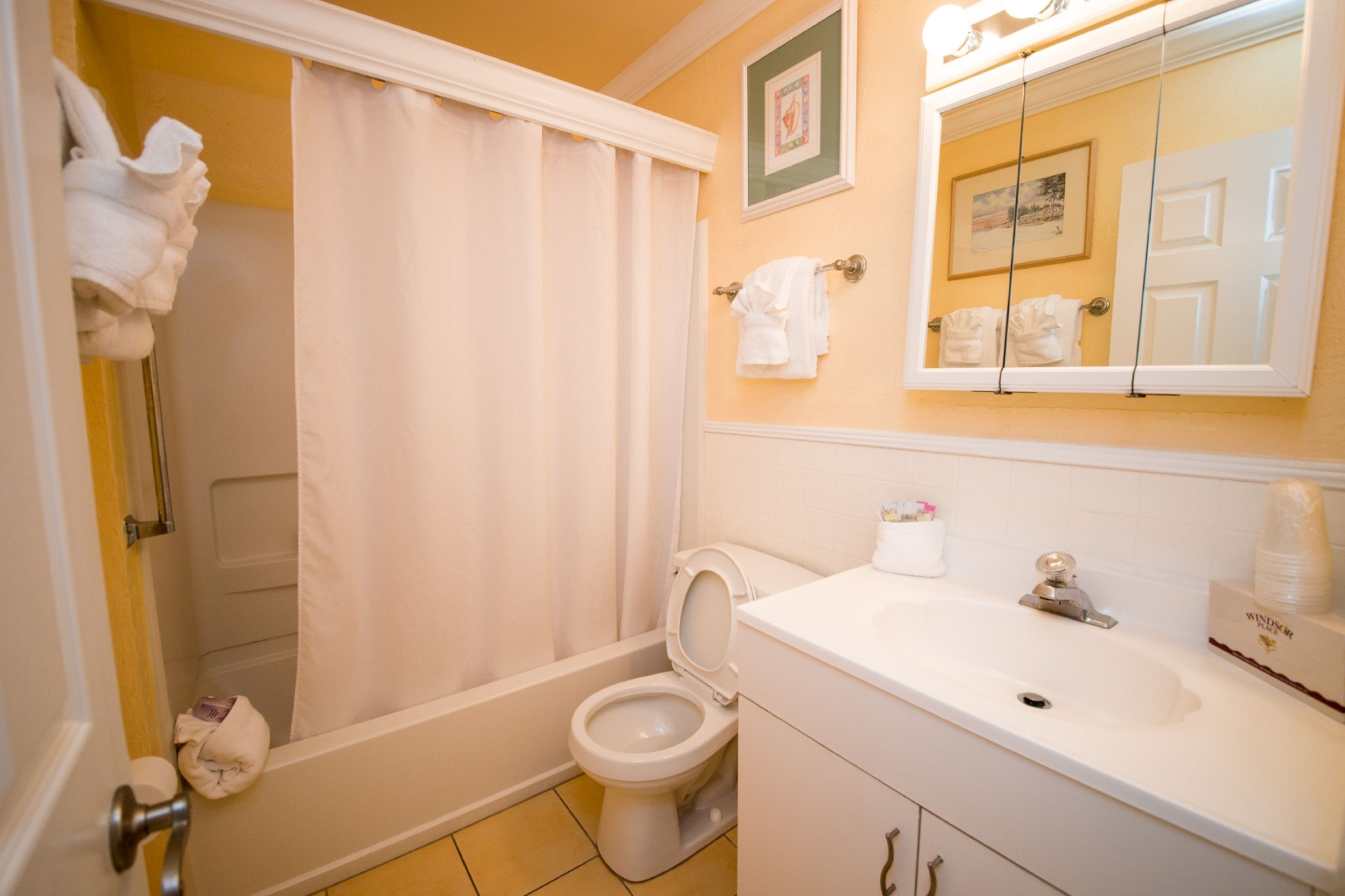 Une salle de bain équipée d’une baignoire, de toilettes, d’un lavabo et d’un miroir.