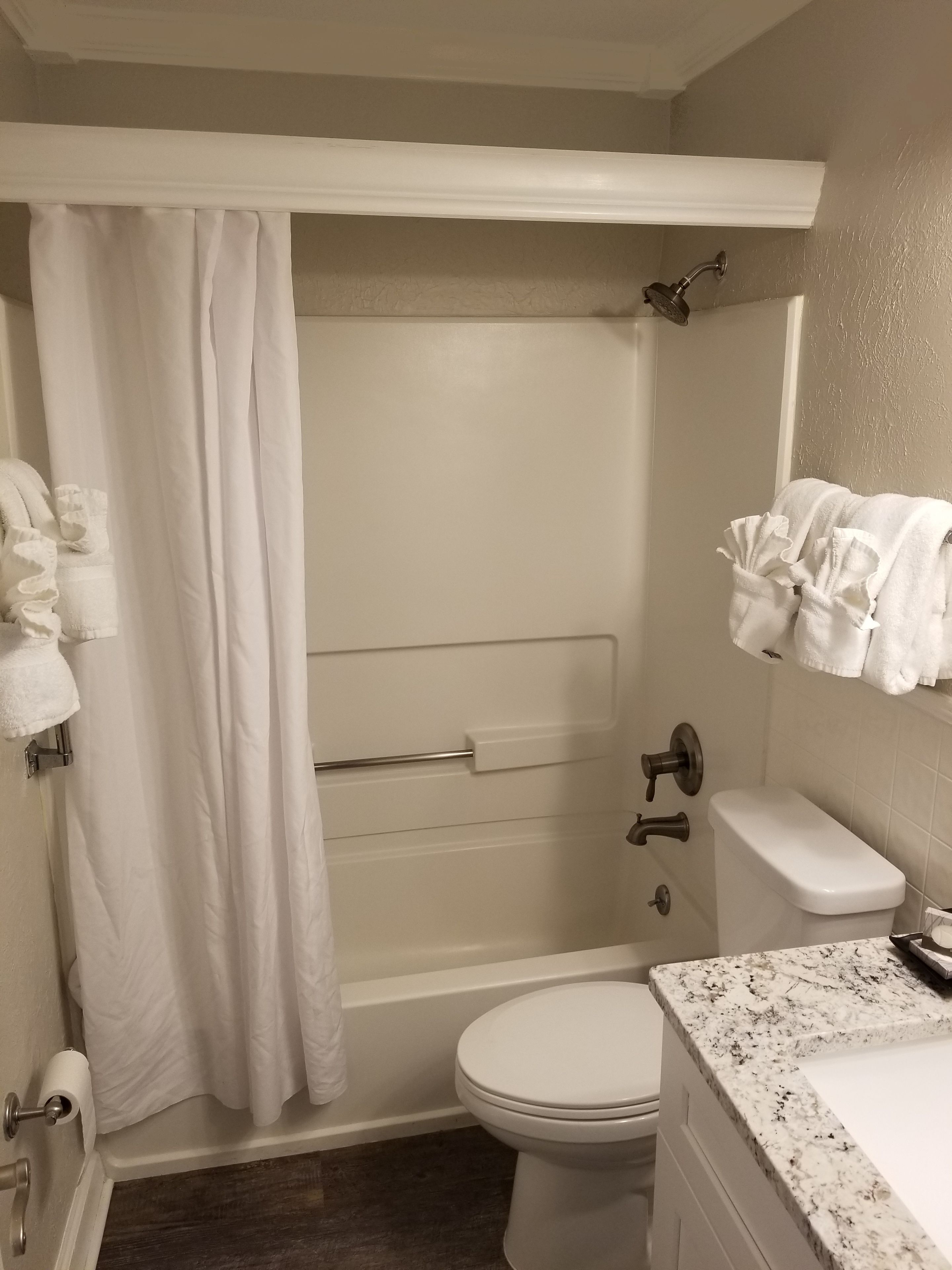 Un baño con bañera, inodoro y lavabo con encimera de mármol.