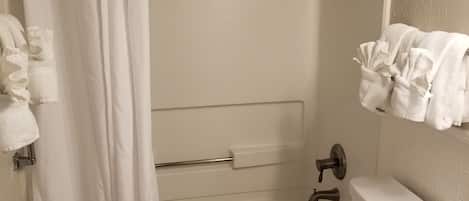 Un baño con bañera, inodoro y lavabo con encimera de mármol.