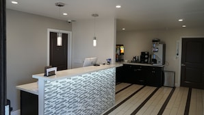 A modern kitchen with a central island, a refrigerator, and a coffee machine. - Muir Woods Lodge (Mill Valley)