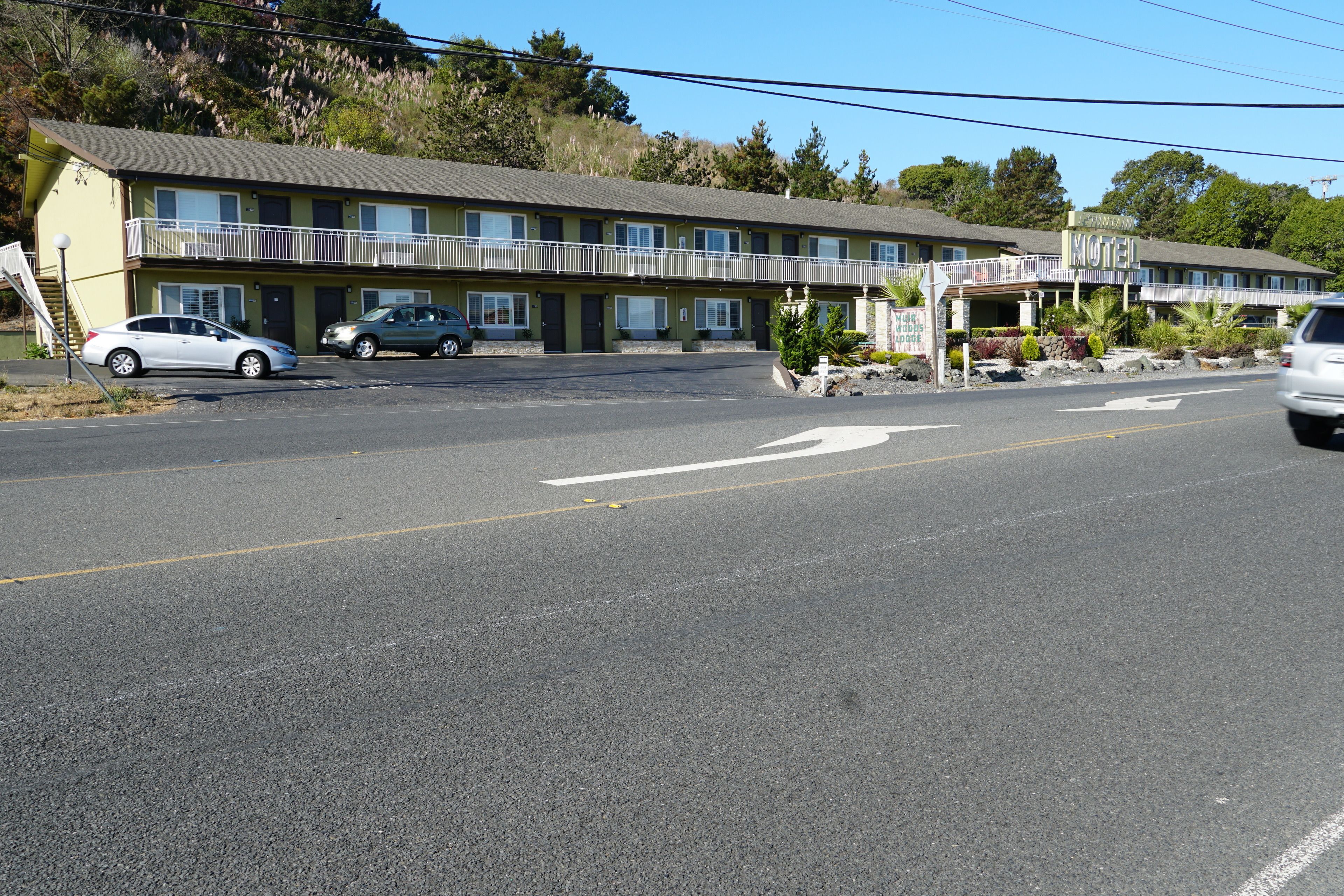 A motel with a two-story structure, a covered parking area, and a visible entrance.