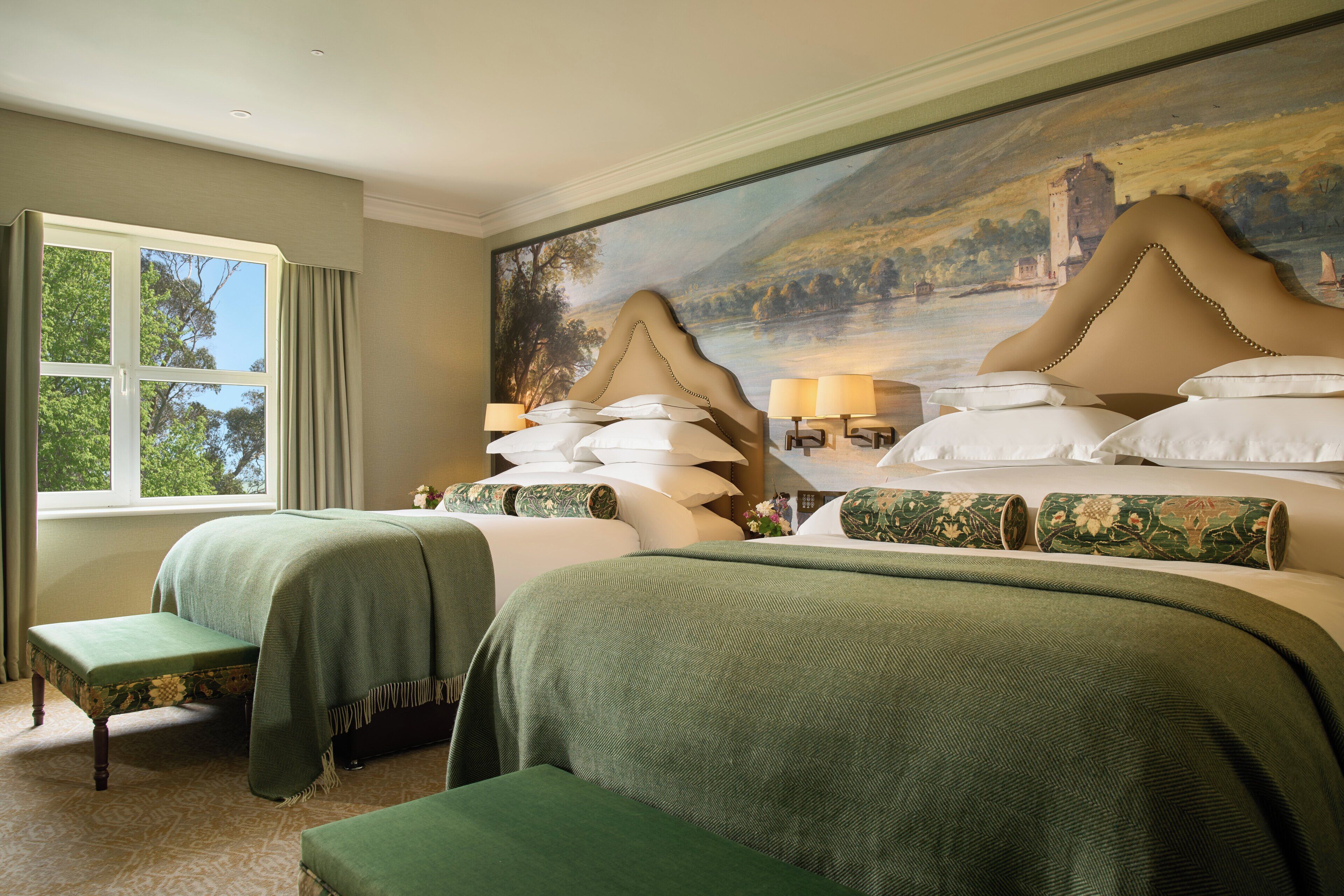 Ein Hotelzimmer mit zwei Betten, einem großen Fenster und einem schönen Gemälde an der Wand.