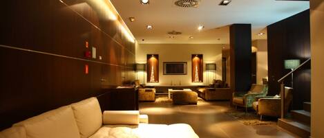 Una sala de estar moderna con sofá, sillones y chimenea.
