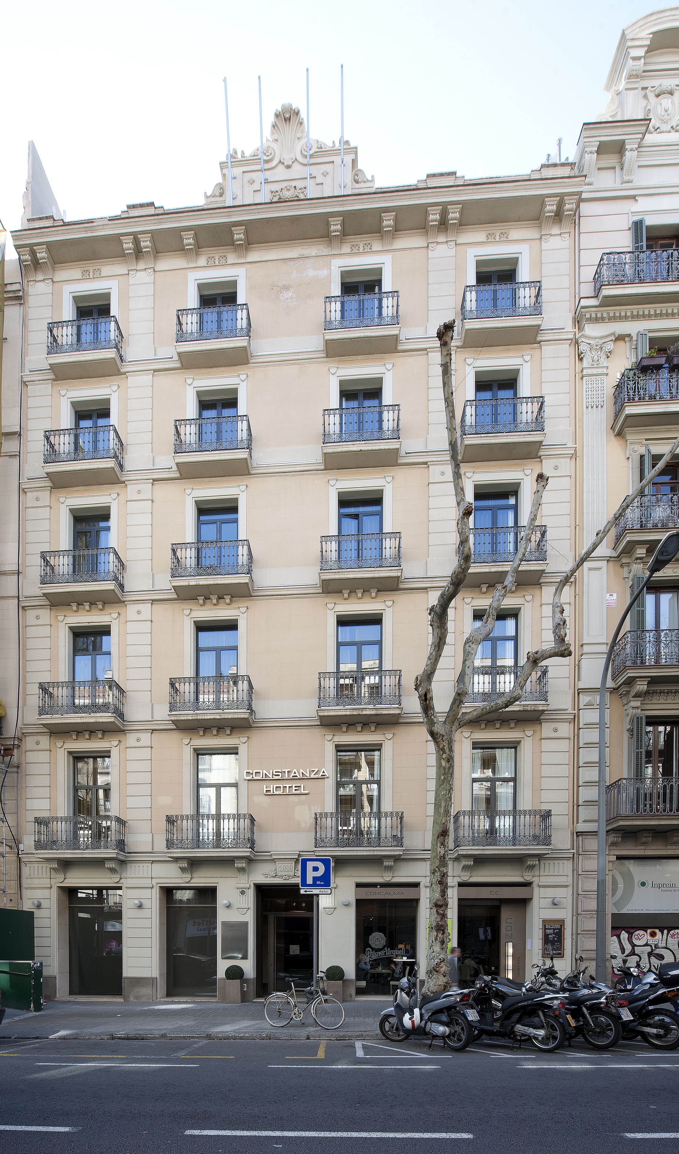 Ein mehrstöckiges Hotel mit klassischer Architektur, mit Balkonen und Metallgeländern sowie einem gut sichtbaren Hotelschild.