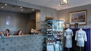 A reception area with a tufted counter, a glass display case with various items, and a framed picture on the wall.