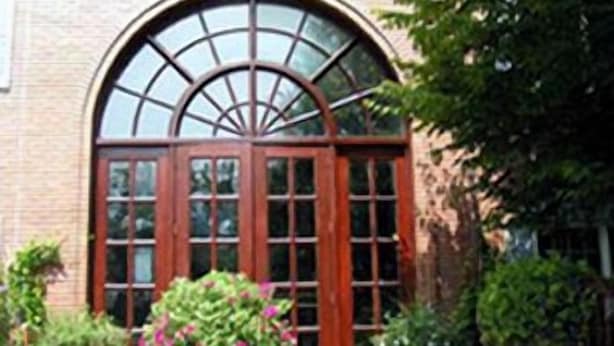 A brick building with a large arched window and a wooden door. - Colts Neck Inn Hotel (Colts Neck)