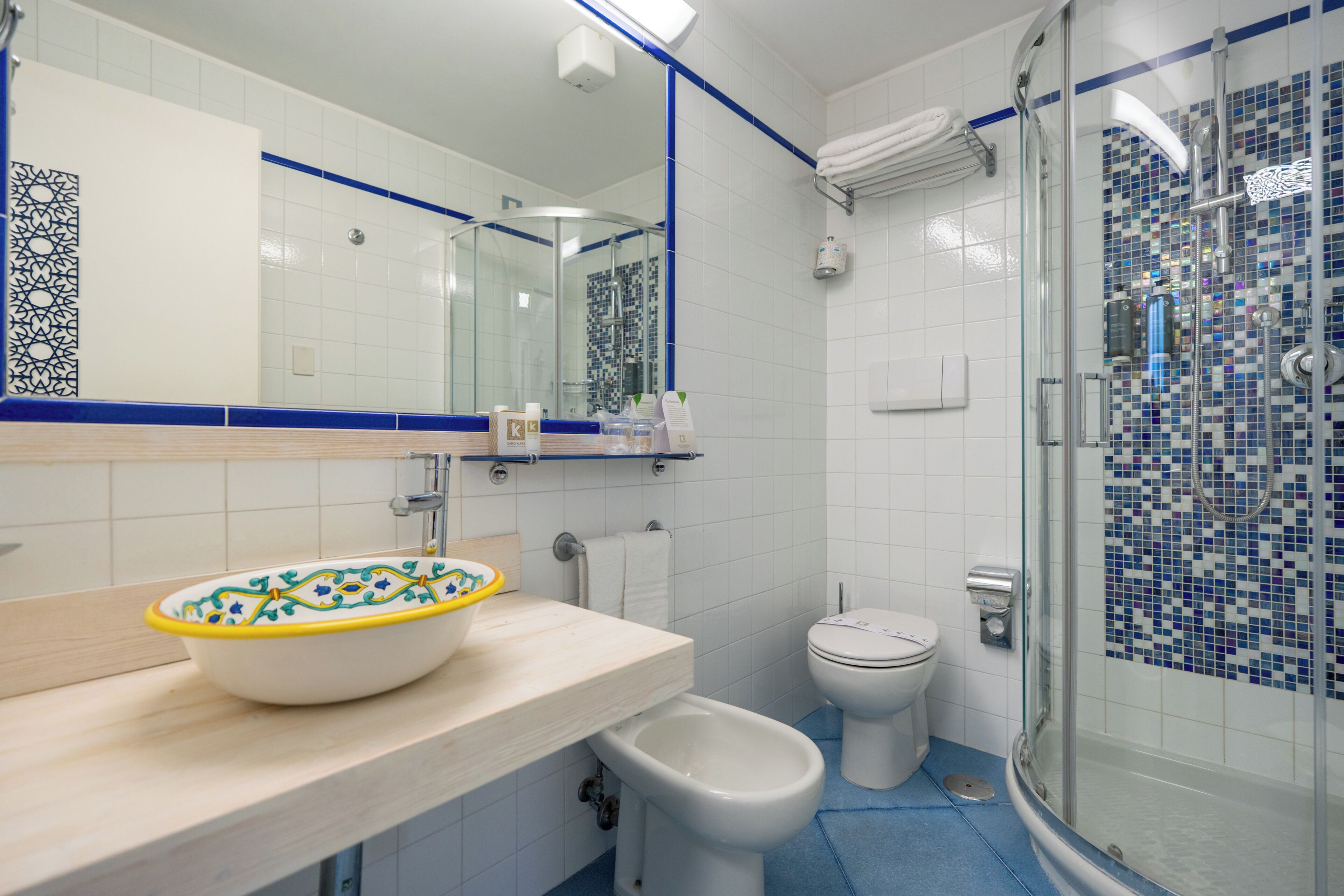 Une salle de bain avec un lavabo blanc, des toilettes, un bidet et un espace douche.