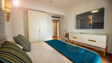 Une chambre d’hôtel avec un lit, une commode, un miroir et une porte.