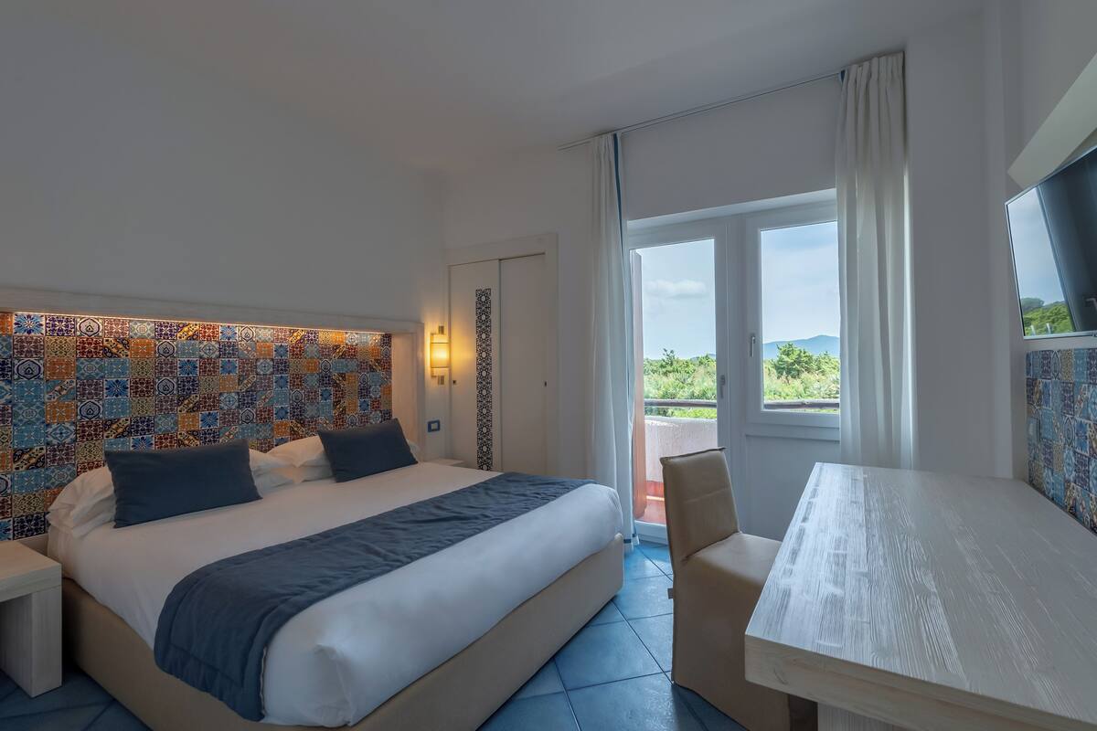Une chambre d’hôtel avec un lit, une table et une vue sur l’extérieur.