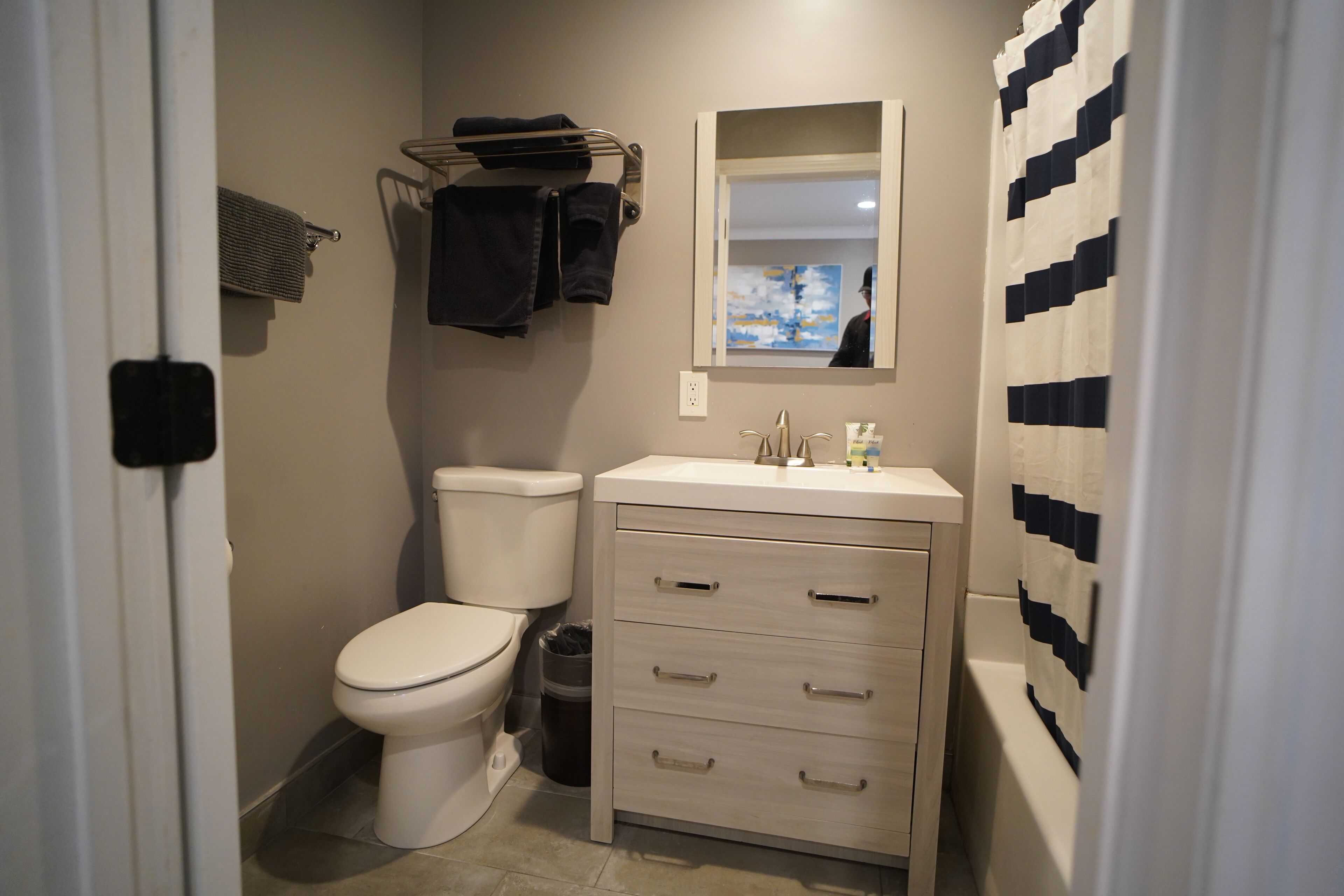 A compact bathroom with a toilet, sink, and storage cabinet.