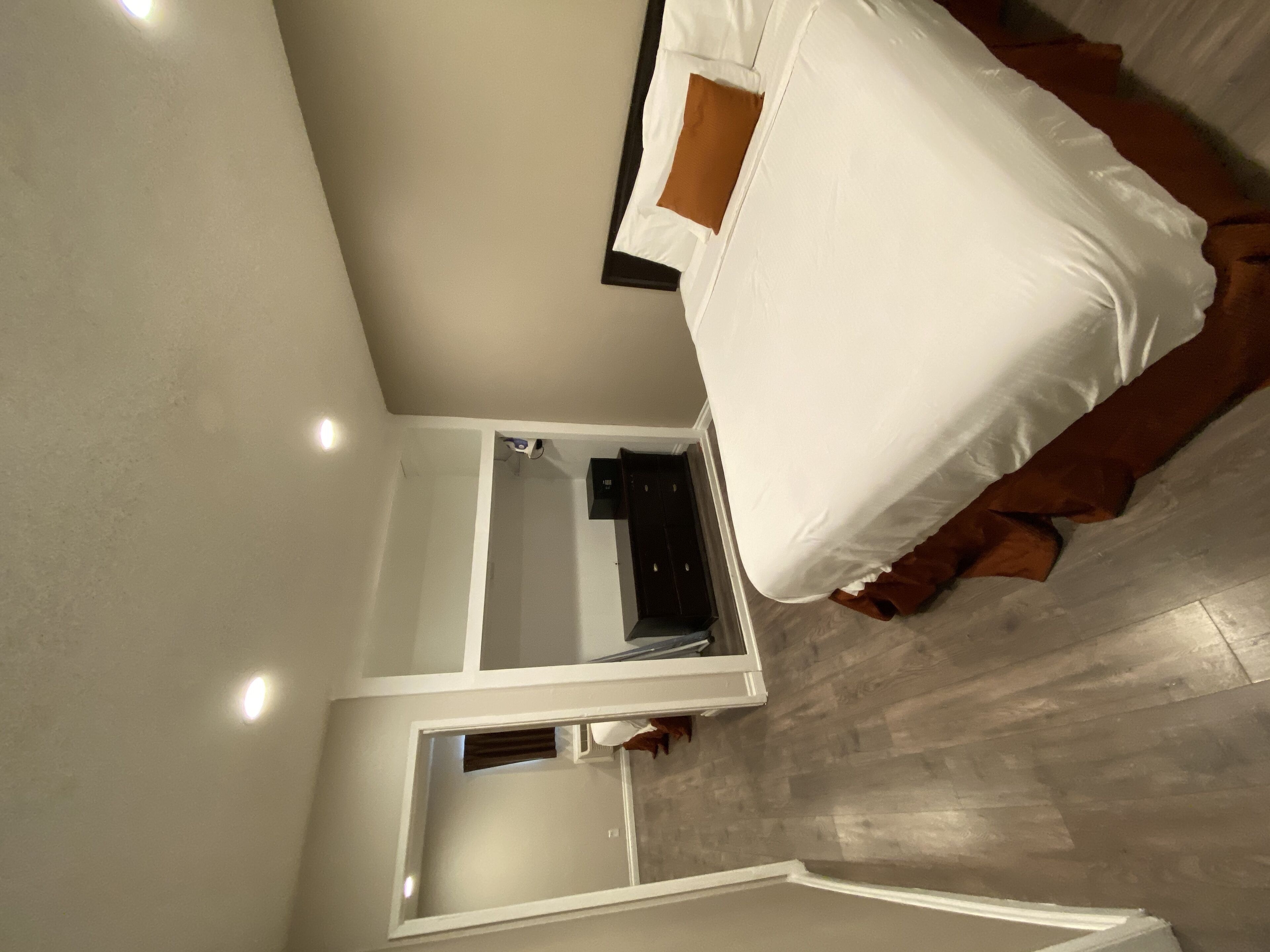 Una habitación con una cama, una mesita y un espejo.