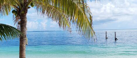På stranden, hvit sand, solsenger og parasoller