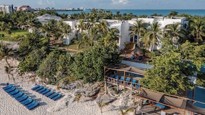 Ett semesterhotell vid stranden med många solstolar och ett poolområde.