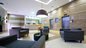 A modern lobby with a reception desk, seating area, and elevators. - Comfort Hotel Taguatinga (Taguatinga)