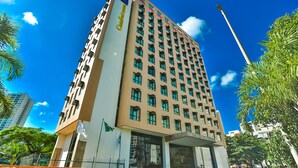 A tall hotel with multiple floors, large windows, and a prominent entrance. - Comfort Hotel Taguatinga (Taguatinga)