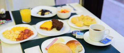 A breakfast table with various dishes including eggs, pastries, and a cup of coffee.