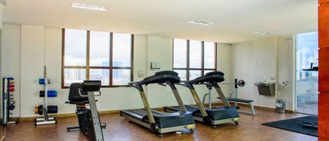 A gym with treadmills, a stationary bike, and weightlifting equipment.