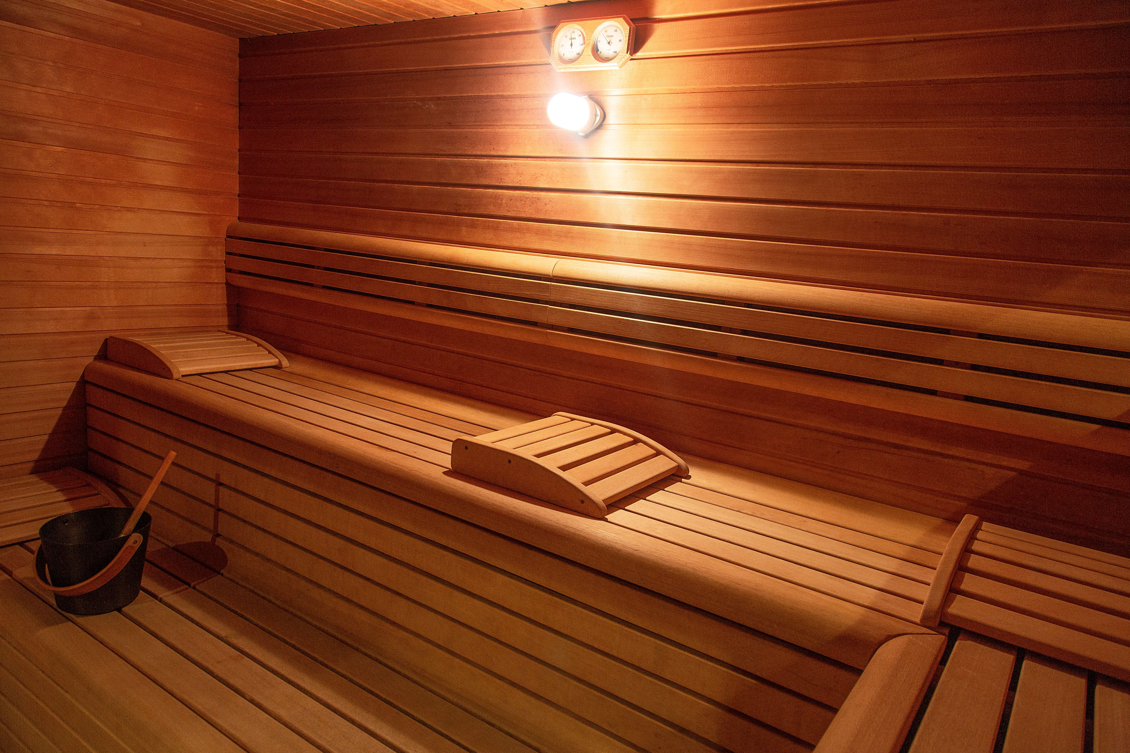 Eine Sauna mit Holzbänken und einer Liege mit Rückenlehne.