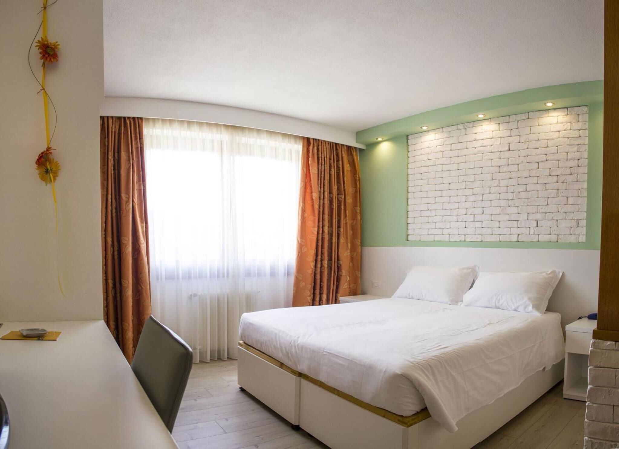 A bedroom with a bed, a desk, and a chair.