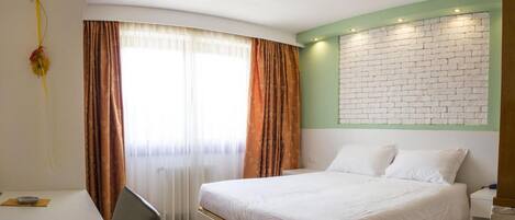 Un dormitorio con cama, escritorio y silla.