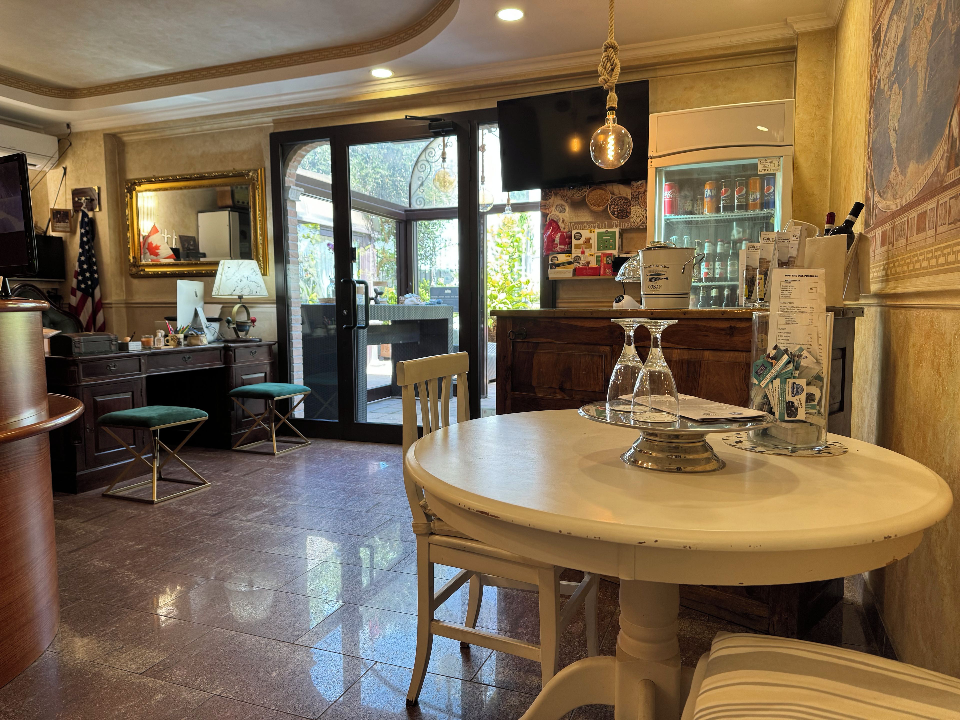 Una cocina bien iluminada con comedor, que incluye una mesa redonda, sillas y un refrigerador lleno de bebidas.