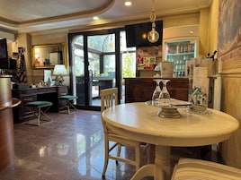 Una cocina bien iluminada con comedor, que incluye una mesa redonda, sillas y un refrigerador lleno de bebidas.