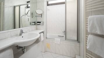 A modern bathroom with a sink, mirror, and shower.