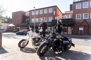 A hotel with a brick facade, a signboard with 'HOTEL' visible, and two motorcycles parked in front. - Best Western Hotel Heide (Oldenburg)