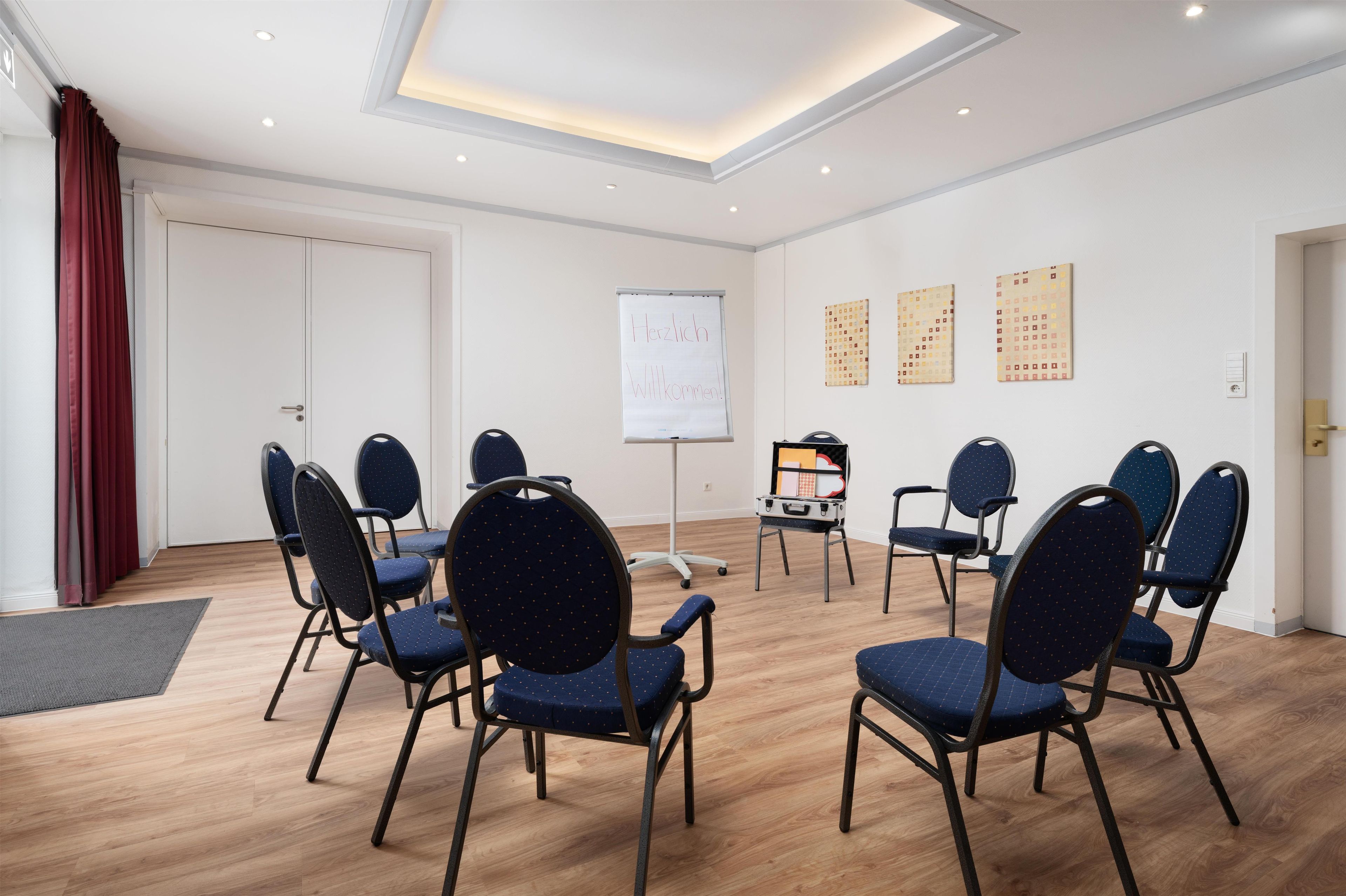 A conference room with a whiteboard, a projector, and a seating arrangement of chairs.