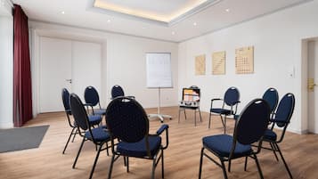 A conference room with a whiteboard, a projector, and a seating arrangement of chairs.